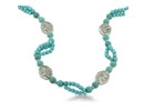 This turquoise and silver tone beaded necklace is perfect for a summer evening out in the city.  The necklace features heavy oval silver tone beads with an antiqued leaf design. This turquoise necklace is 32 1/2 inches long and has  a lobster claw clasp.